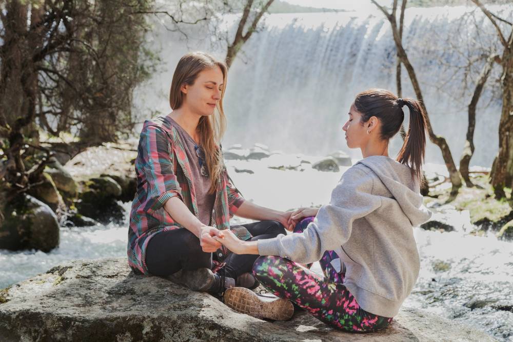 Two women engaging in a guided breathwork session in nature, showcasing the outdoor and holistic experiences of Breathwork Classes in Denver.